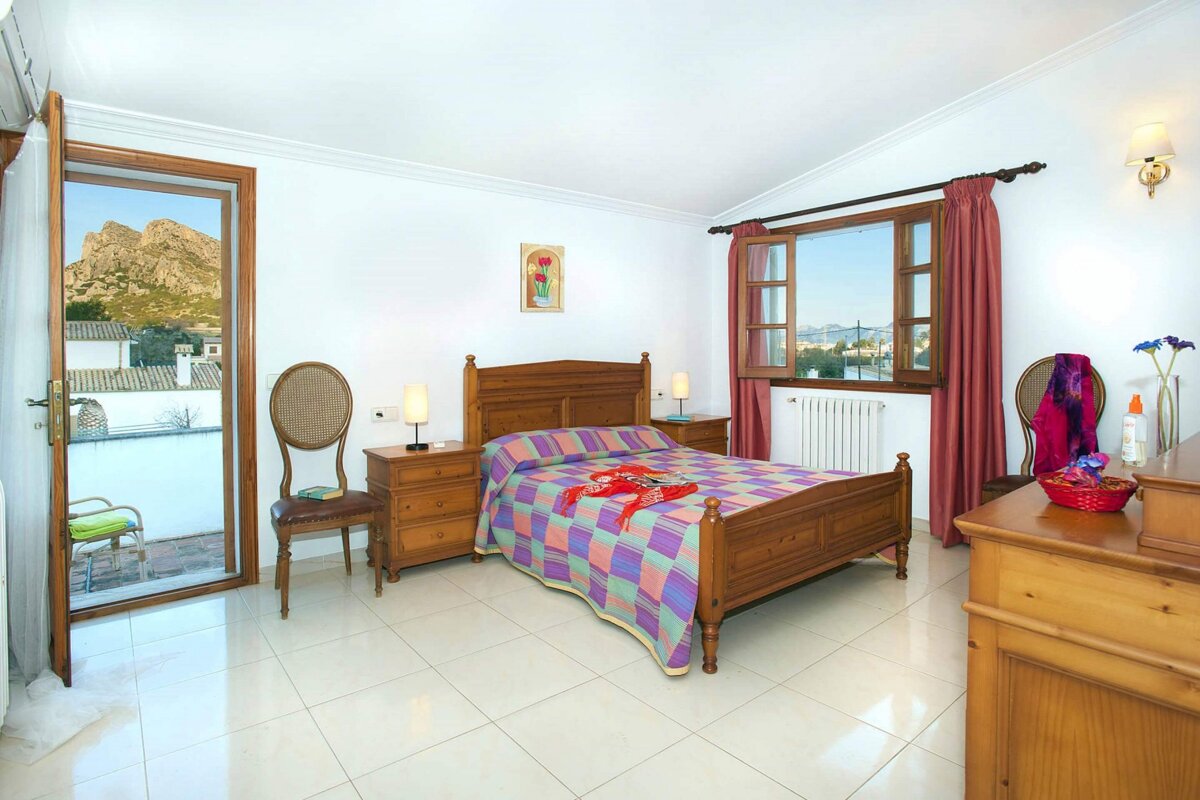 A bedroom with a large bed and a dresser