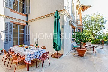 A table and chairs on a patio with the word home on the wall