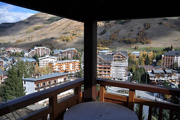 A balcony with a view of a city and mountains