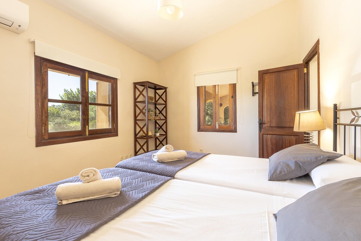 A bedroom with two beds and a window