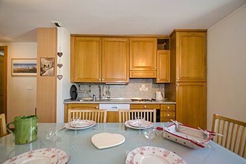 A kitchen with wooden cabinets and a picture of a beach on the wall