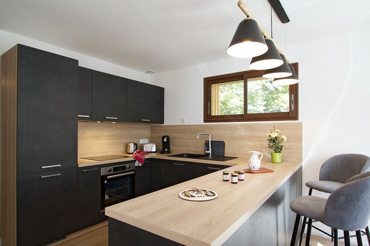 A kitchen with black cabinets and a wooden counter top