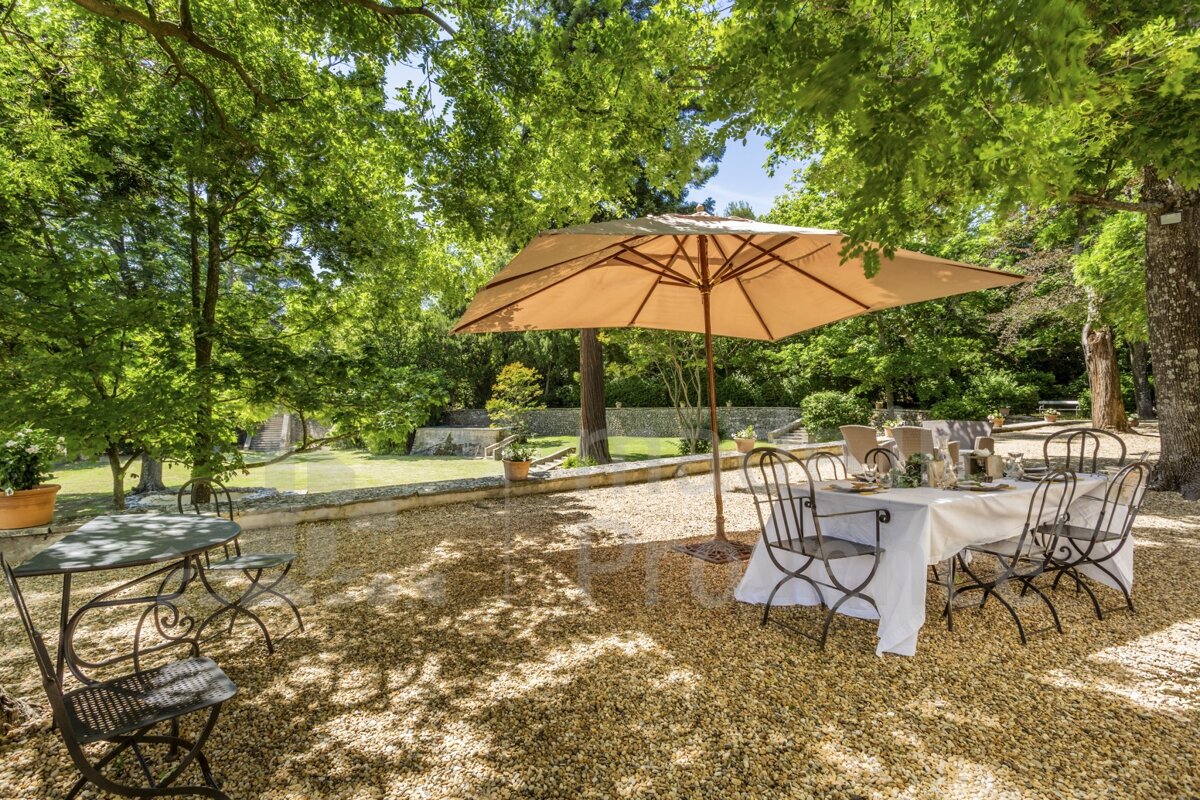 A table and chairs under an umbrella outside