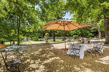 A table and chairs under an umbrella outside