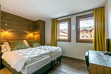 A hotel room with a large bed and a balcony