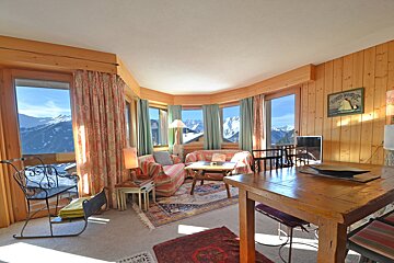 A living room with a table and chairs and a sign that says glacier du jura