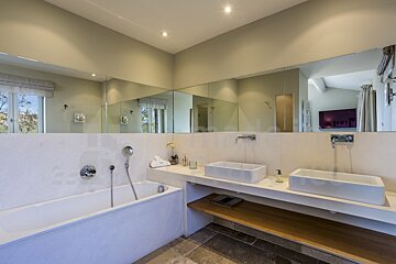 A bathroom with two sinks and a large mirror