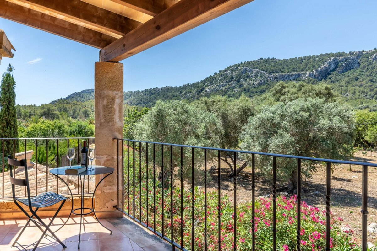 A balcony with a view of trees and mountains