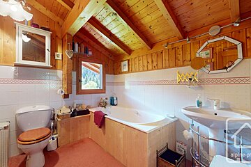 A bathroom with a tub and a toilet and a sign that says alpine-pr