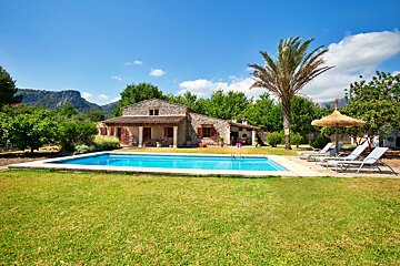 A house with a large swimming pool in front of it