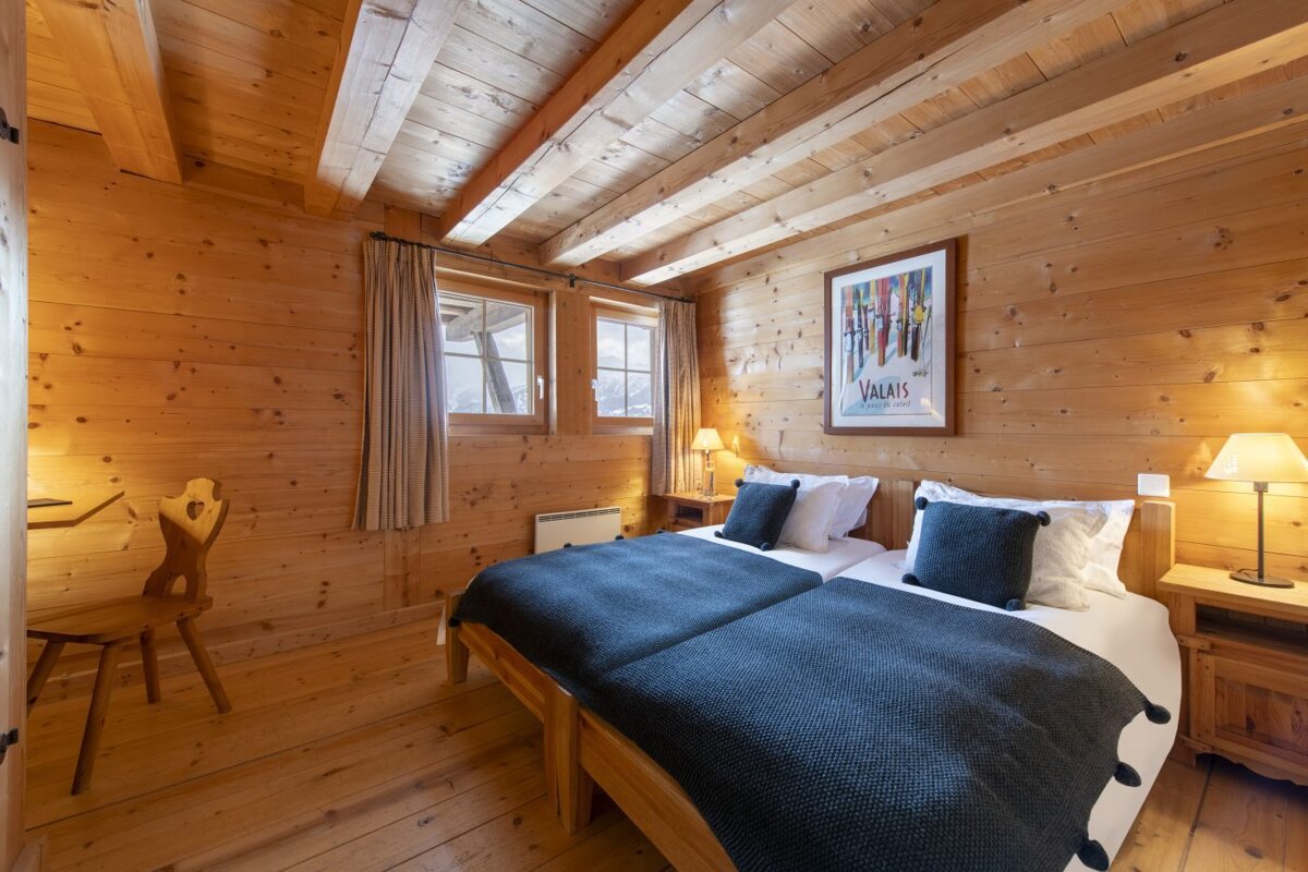 A bedroom with two beds and a picture on the wall that says valais
