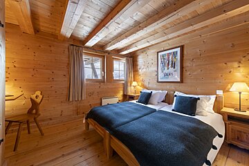 A bedroom with two beds and a picture on the wall that says valais