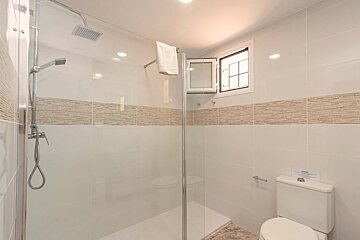 A bathroom with a toilet a shower and a window