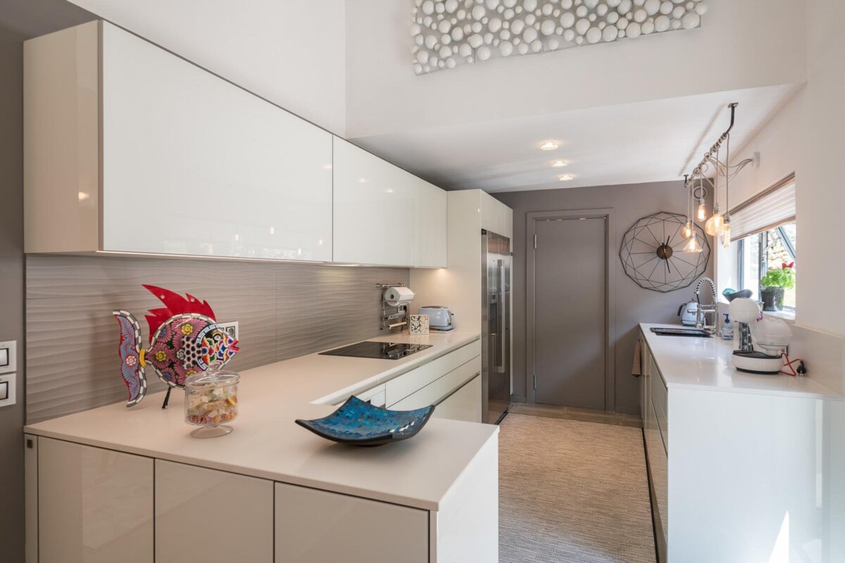 A kitchen with white cabinets and a blue bowl on the counter