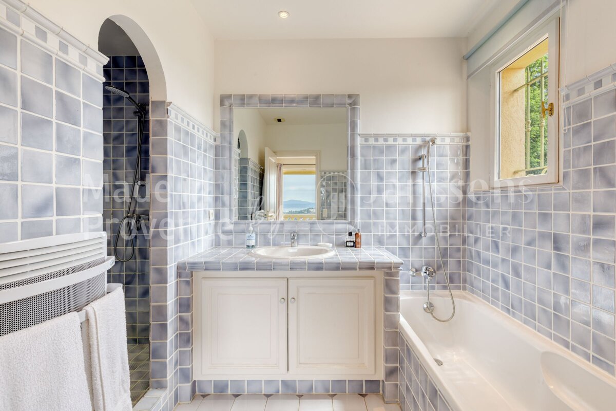 A bathroom with blue tiles and the word provence on the wall