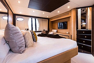 A bedroom with a bed and a television on the wall