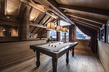 A pool table in a room with a large window