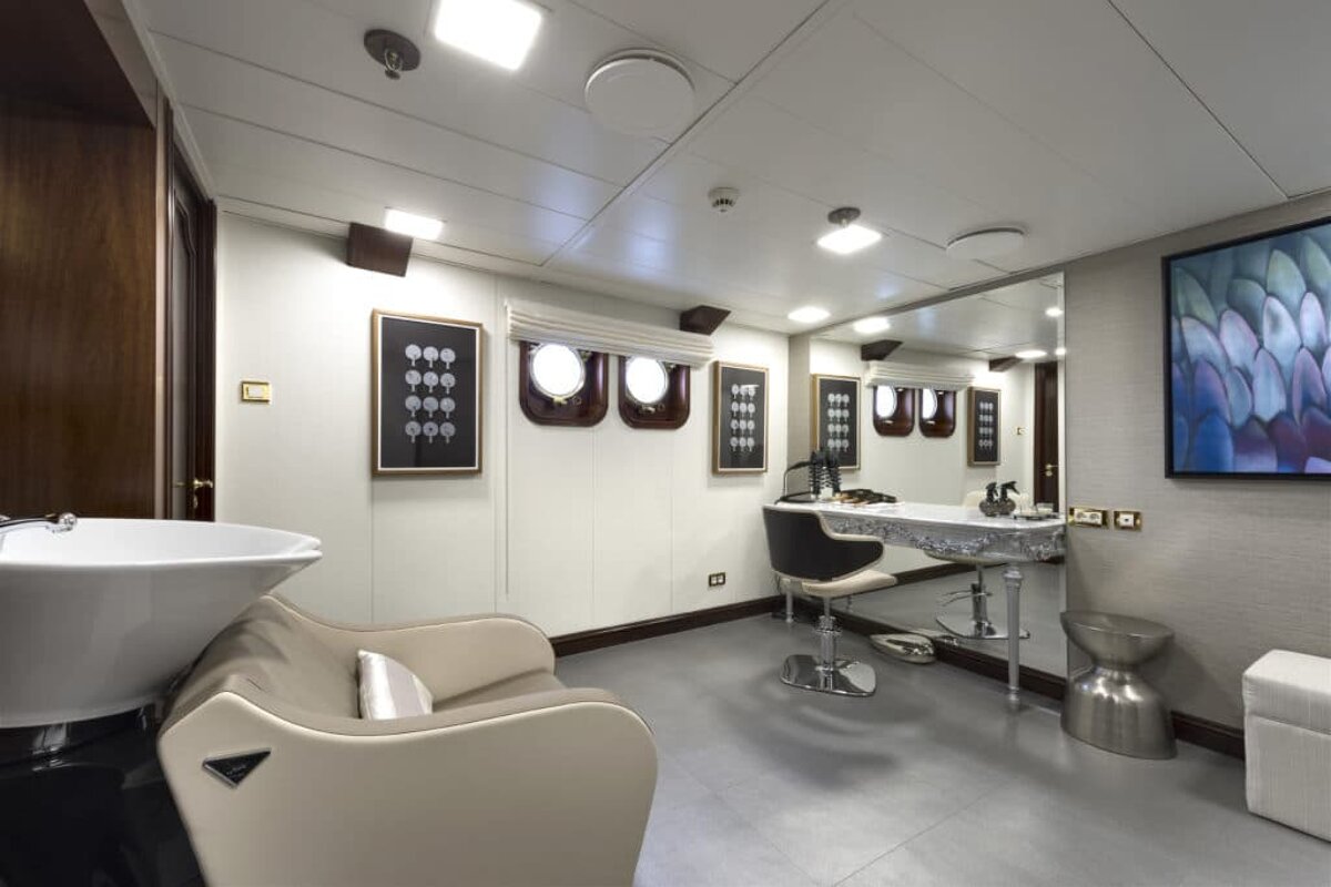 A room with a chair a sink and a mirror