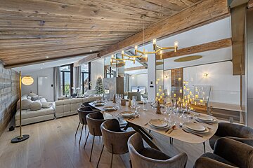 A dining room table with plates and glasses on it