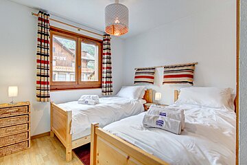 A bedroom with two twin beds and a dresser
