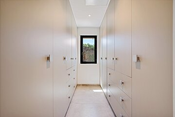 A walk in closet with lots of drawers and a window