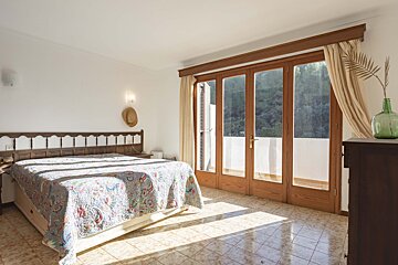 A bedroom with a large bed and sliding glass doors