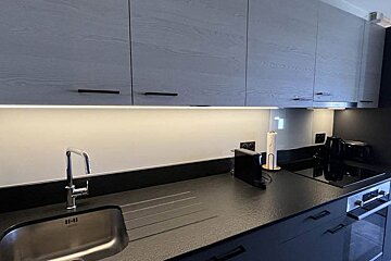 A kitchen with a sink and a toaster oven