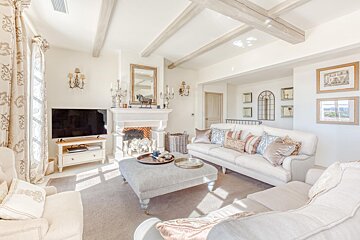 A living room with white furniture and a fireplace