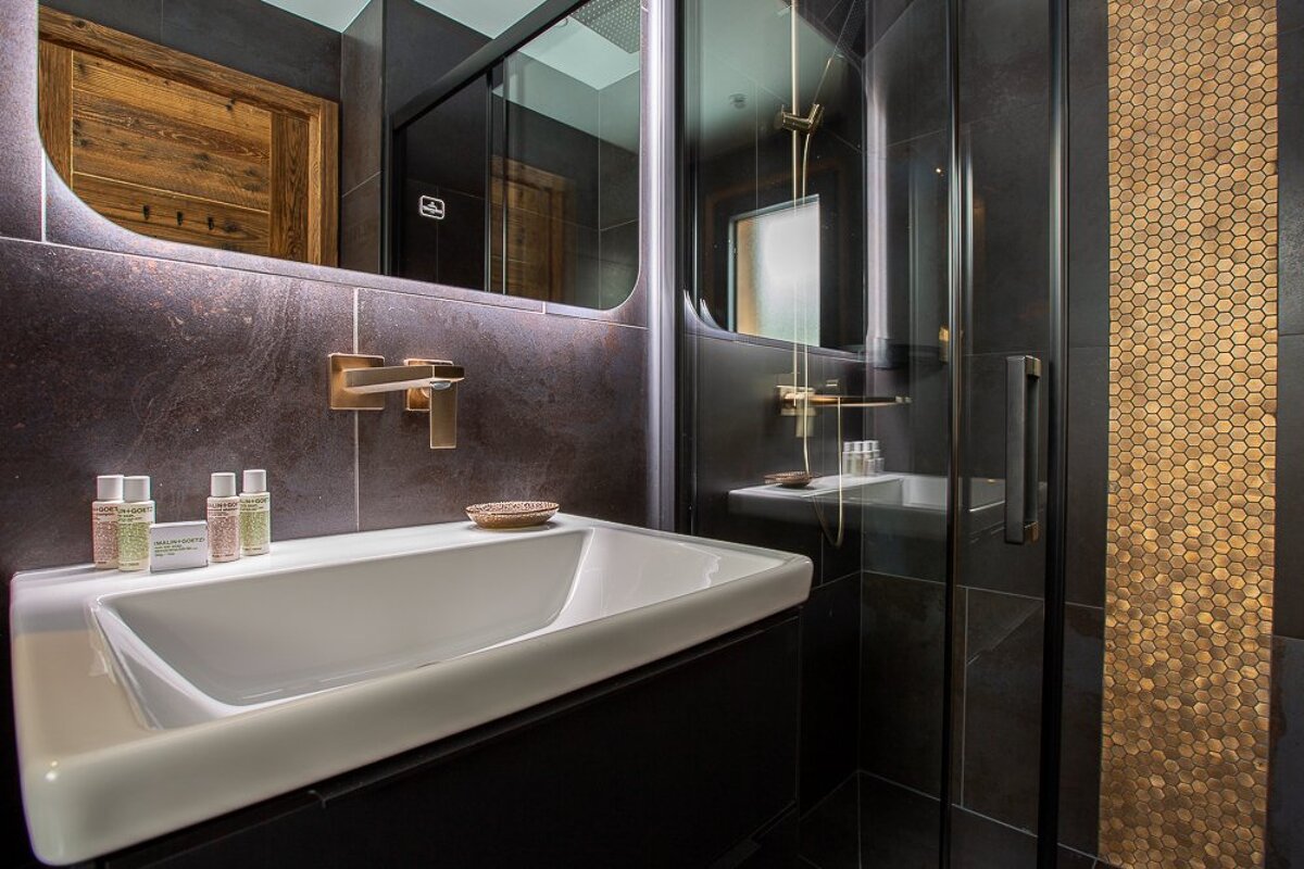 A bathroom with a sink and a mirror with the letter b on it