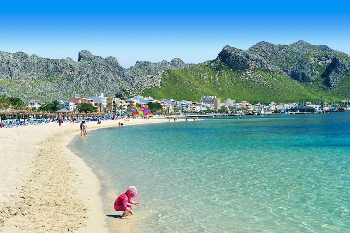 A little girl is playing in the water on a beach