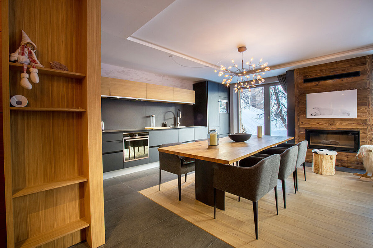 A kitchen with a wooden table and chairs