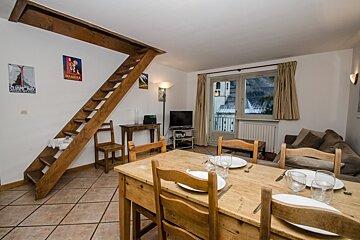 A living room with a staircase leading up to the second floor
