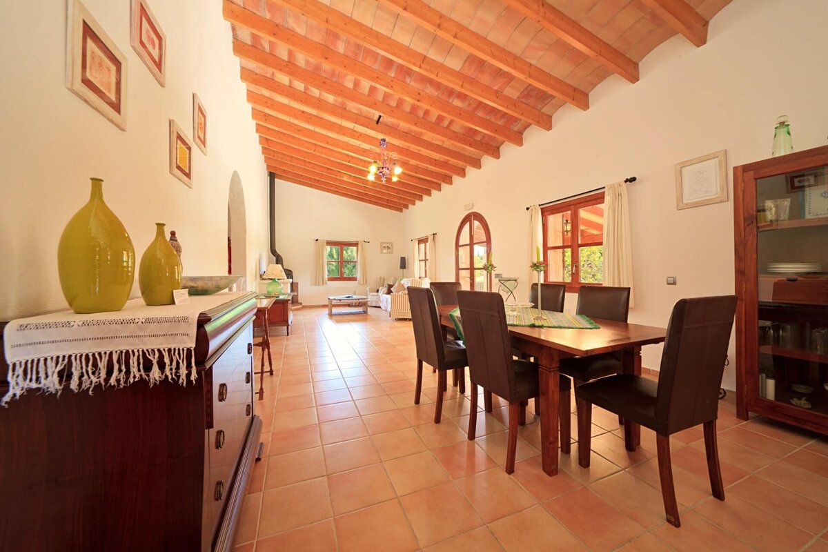 A dining room with a table and chairs and a dresser