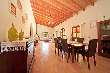 A dining room with a table and chairs and a dresser