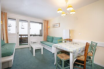A living room with a dining table and chairs