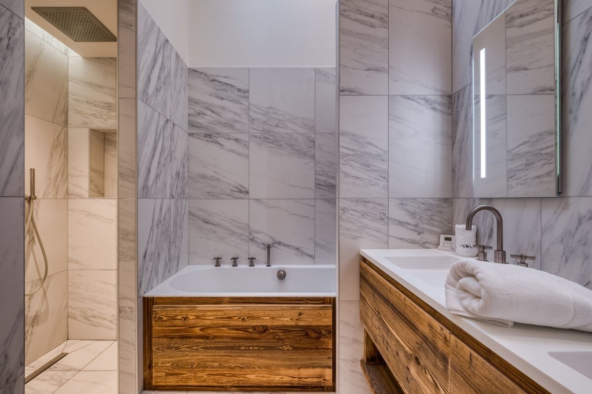 A bathroom with marble tiles and a bathtub