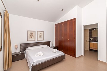 A bedroom with a large bed and a closet