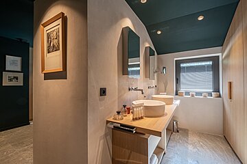 A bathroom with two sinks and a picture on the wall