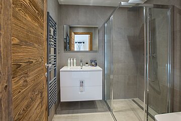 A bathroom with a sink and a walk in shower