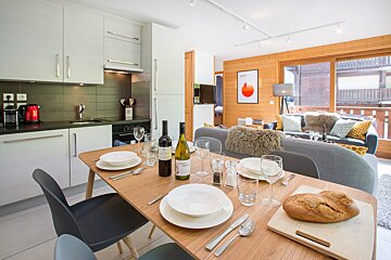 A bottle of wine sits on a table in a kitchen