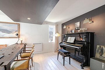 A piano in a room with a painting on the wall above it