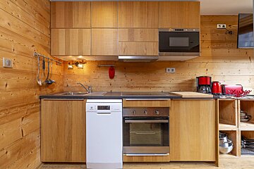 A kitchen with wooden cabinets and a white electrolux dishwasher
