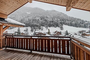 A balcony with a view of snowy mountains and houses