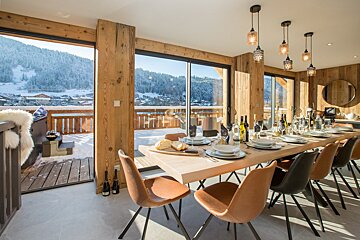 A dining room with a large table and chairs