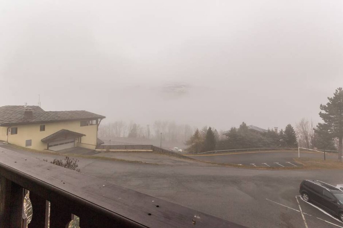 A view of a house and a parking lot in the fog