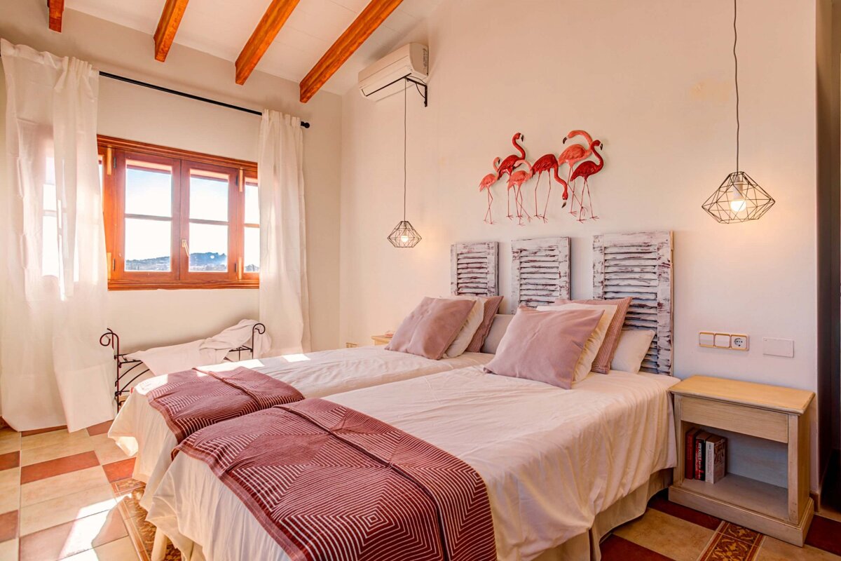 A bedroom with two beds and flamingos on the wall
