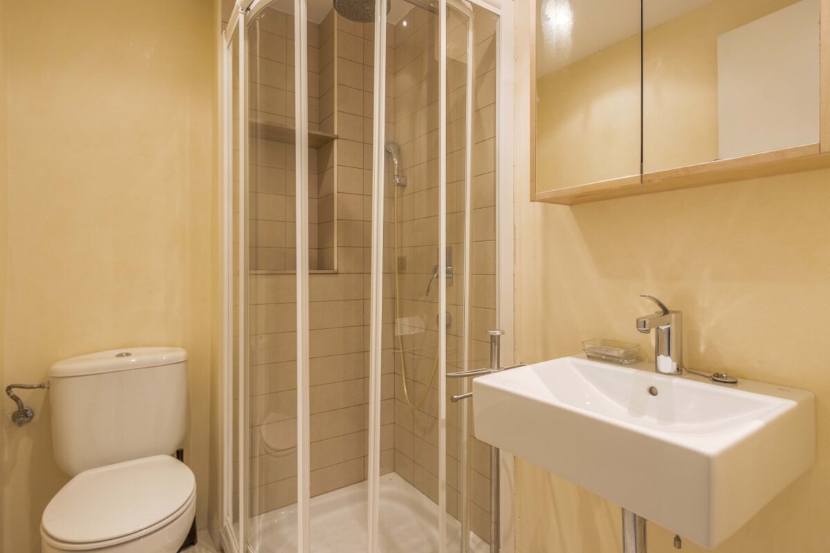 A bathroom with a toilet a sink and a shower