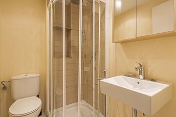 A bathroom with a toilet a sink and a shower