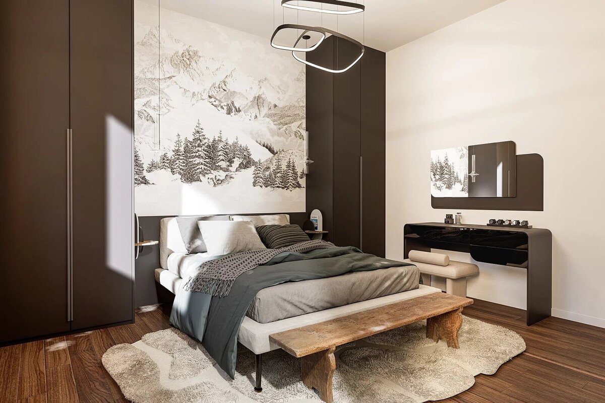 Modern bedroom featuring a mountain landscape mural, a grey bed with a rustic wooden bench, dark wardrobes, and a sleek vanity.