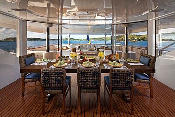 A large dining area on a boat with a table and chairs